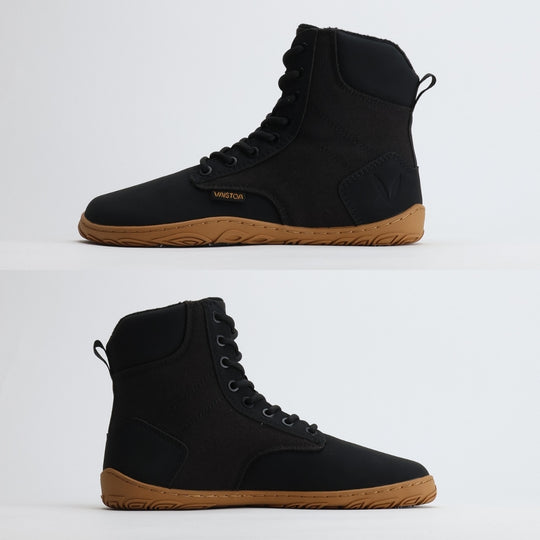 Black barefoot winter boot showing a flat zero-drop sole from medial and lateral angles on a light gray background.