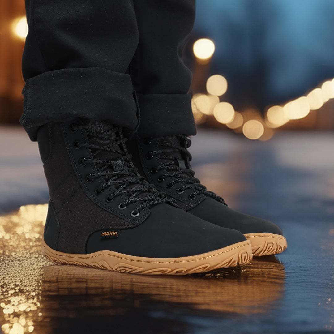 Black barefoot winter boots worn while standing in an evening city setting, showcasing their minimalist Nordic design, warmth, and natural movement feel.