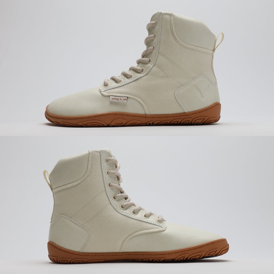 Off white barefoot winter boot showing a flat zero-drop sole from medial and lateral angles on a light gray background.