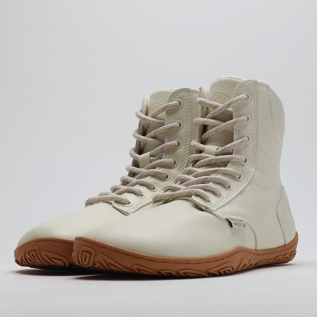 Pair of off white barefoot winter boots shown from a front angle on a light gray background.