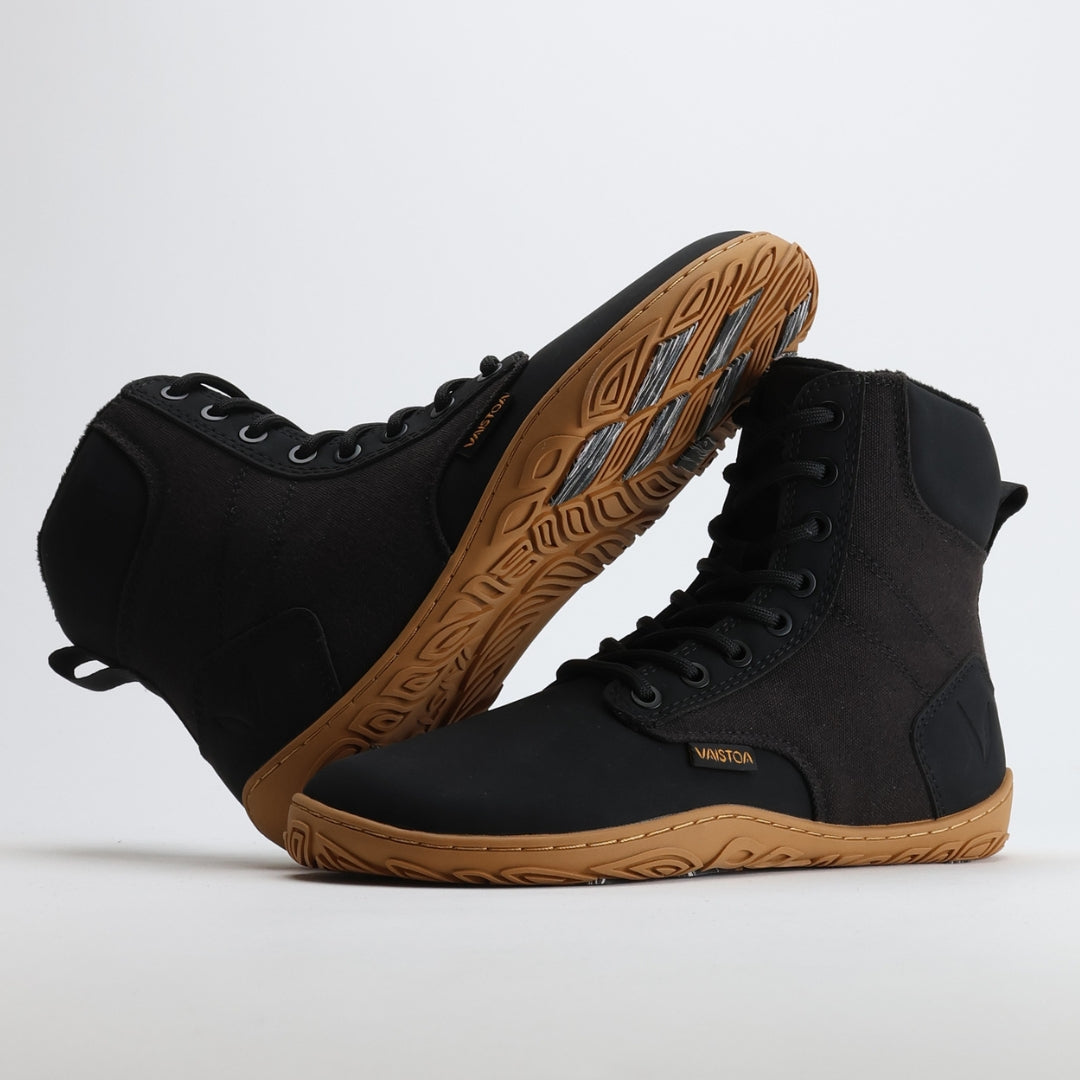 Black barefoot winter boot with the sole resting against the upper, showing visible grip zones on the Vaistoa Pitoa™ winter sole.