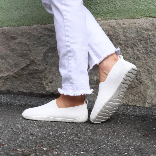 Vaistoa Lempeä 2 barefoot slip-on shoes white – lifestyle photo, white jeans walking on asphalt
