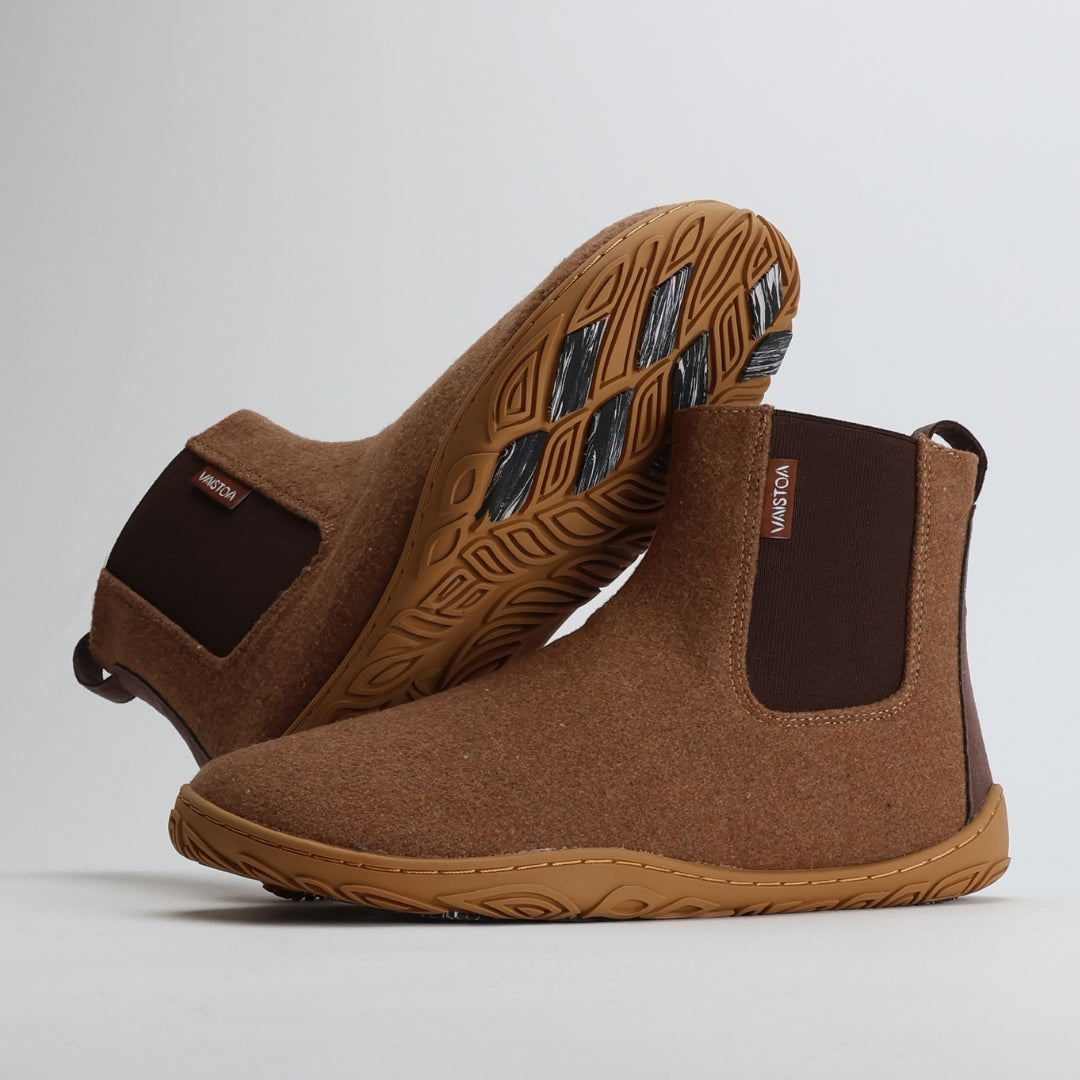 Roasted almond barefoot winter felt Chelsea boots shown from the lateral side, with one boot leaning against the other to display the natural shape and flexible structure.