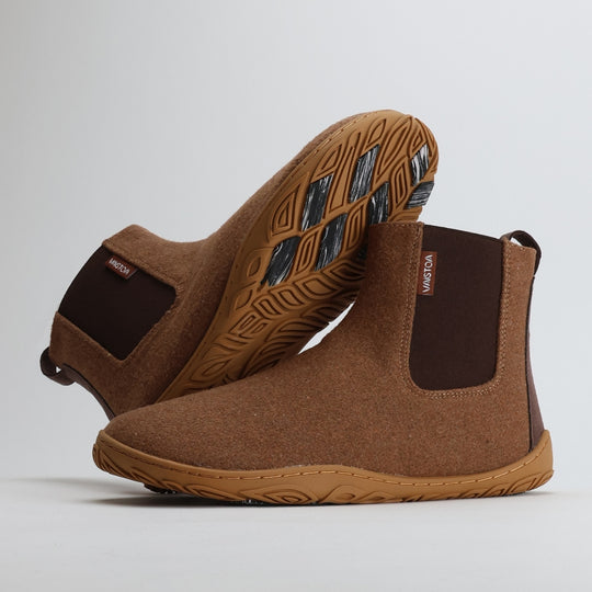 Roasted almond barefoot winter felt Chelsea boots shown from the lateral side, with one boot leaning against the other to display the natural shape and flexible structure.