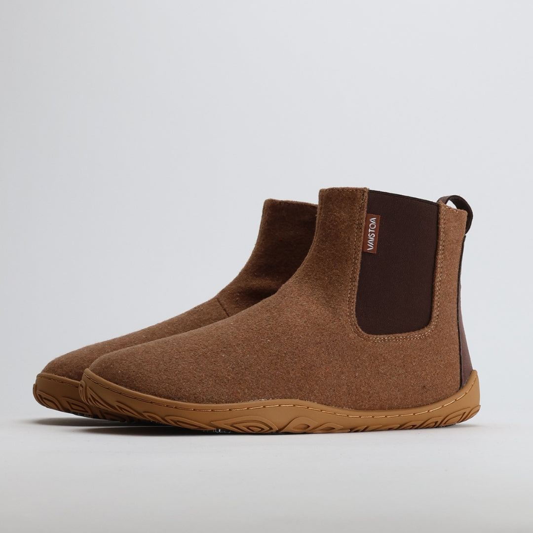 Pair of roasted almond barefoot winter felt Chelsea boots shown from a front angle on a light gray background.