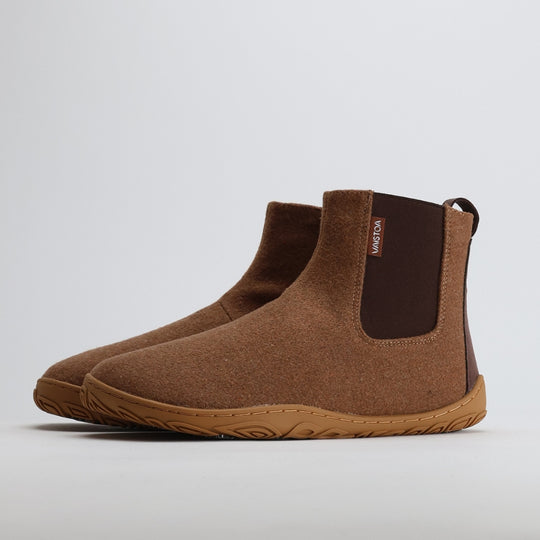 Pair of roasted almond barefoot winter felt Chelsea boots shown from a front angle on a light gray background.