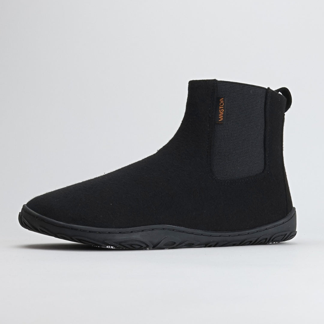 Single velvet black barefoot winter felt Chelsea boot shown from a front angle on a light gray background, highlighting its sleek shape and minimalist Nordic design.