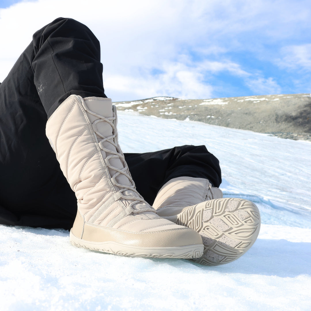 Vaistoa Hanki 3 winter boots on snow, one boot showing the sole and grip pads.