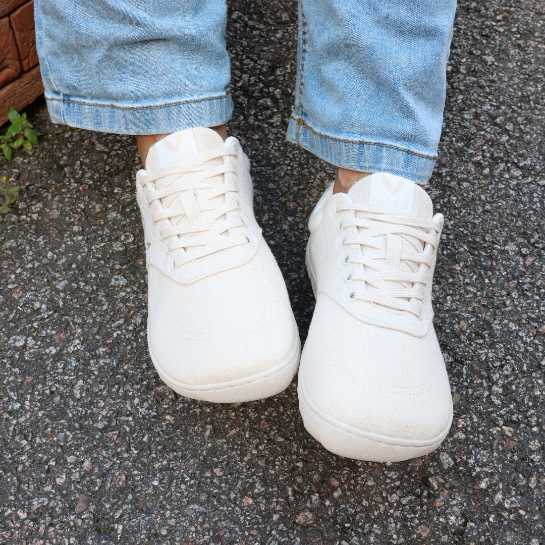 Vaistoa Huoleton barefoot hemp sneakers – natural hemp, shoes worn on asphalt photographed from above with blue jeans, both shoes visible