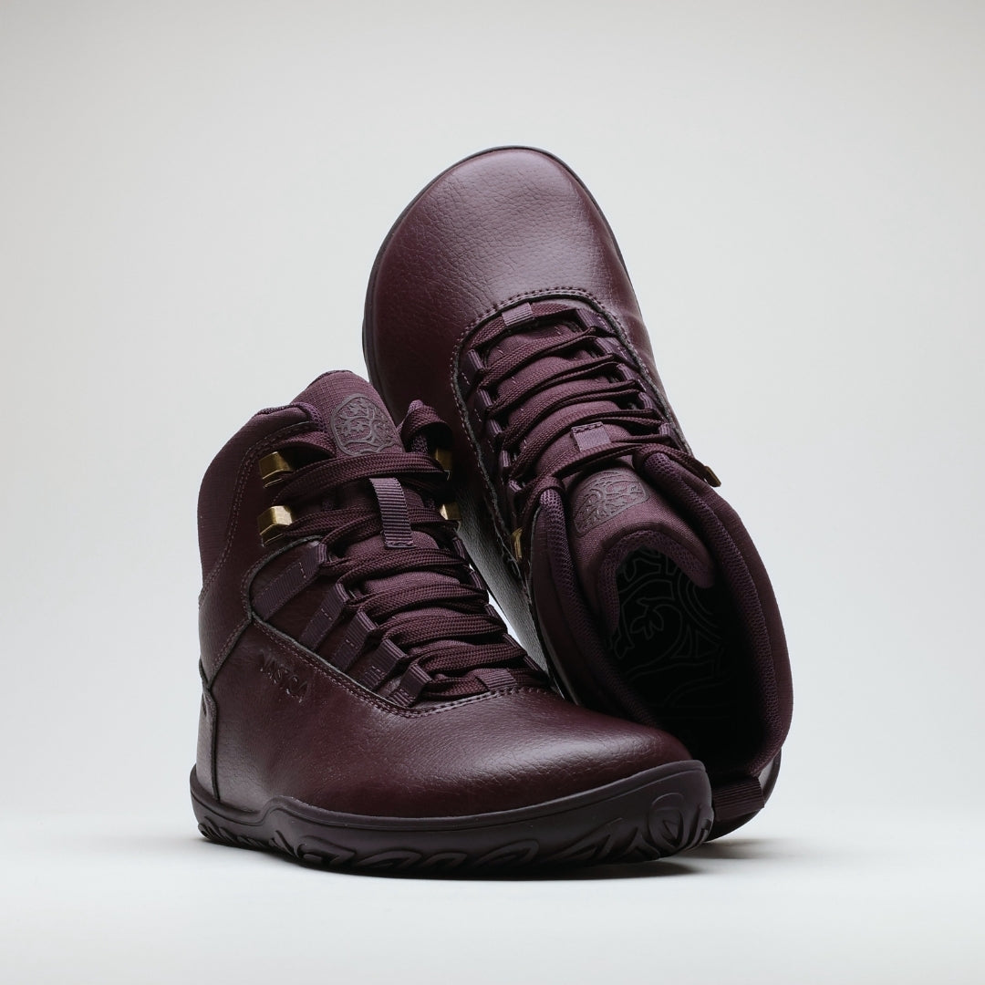 Vaistoa Uoma 2 barefoot trekking boots plum red – the pair arranged with the rear boot tipped toe-up over the front one, so that its patterned insole is visible through the collar opening