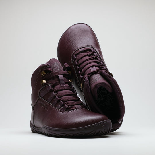 Vaistoa Uoma 2 barefoot trekking boots plum red – the pair arranged with the rear boot tipped toe-up over the front one, so that its patterned insole is visible through the collar opening