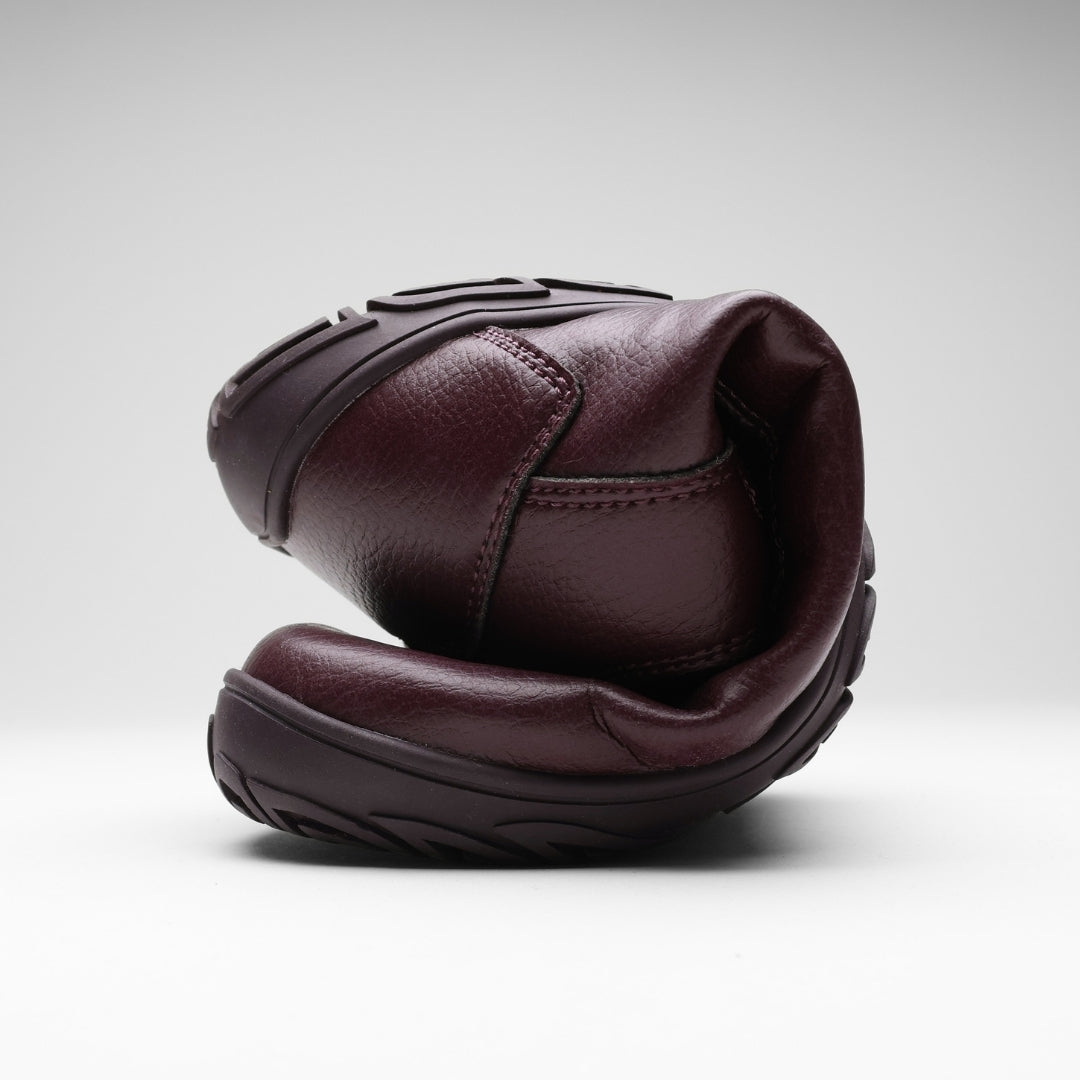 Vaistoa Uoma 2 barefoot trekking boots plum red – one boot folded in half so that the toe bends almost to the heel, showing how flexible the outsole is
