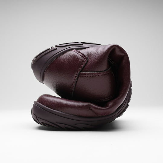 Vaistoa Uoma 2 barefoot trekking boots plum red – one boot folded in half so that the toe bends almost to the heel, showing how flexible the outsole is