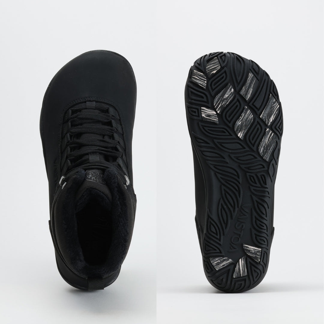 Ylhäältä ja pohjasta kuvattu noenmusta Vaistoa Uoma Talvi 3 -kenkäpari. Kuvassa korostuu leveä, jalan anatomian mukainen varvastila ja pitävä Vaistoa Pitoa™ -talvipohja.