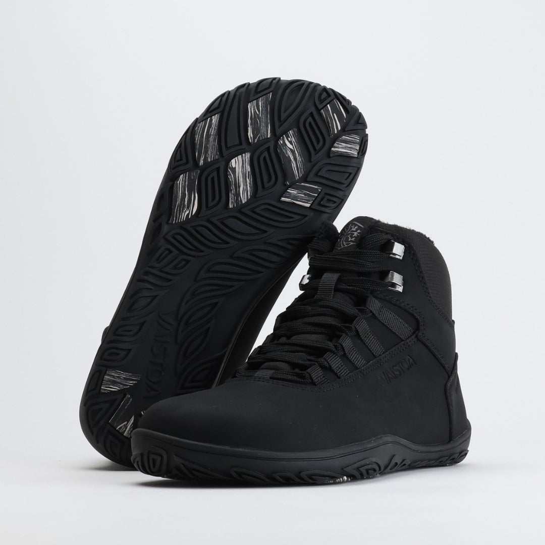 Black barefoot hiking boots with the “Design from Finland” label, representing Finnish design and craftsmanship focused on natural movement and functionality.