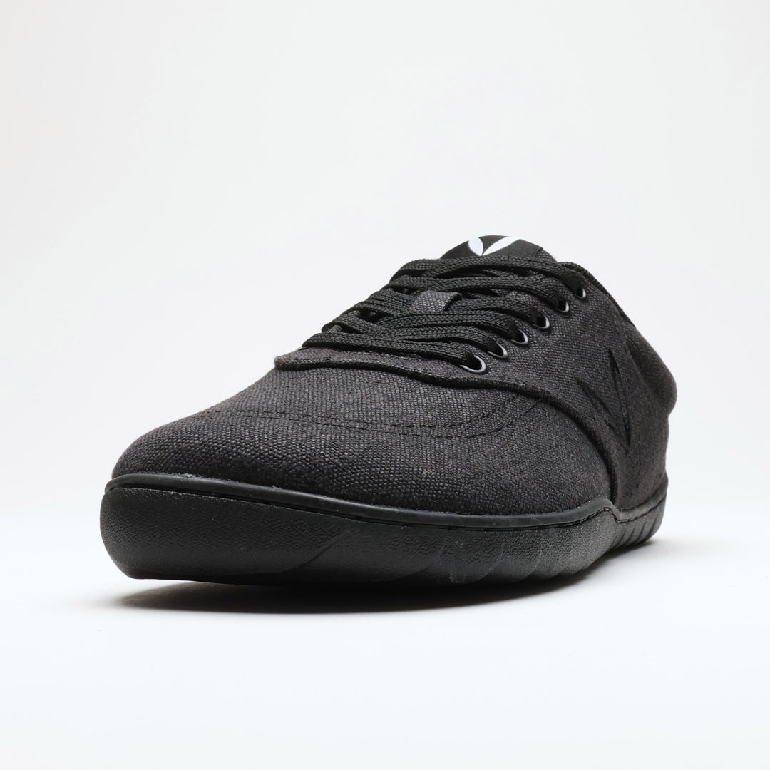 Vaistoa Huoleton barefoot hemp sneakers – soft black, close-up of a single shoe from a front angle, the weave of the hemp fabric and the lacing visible