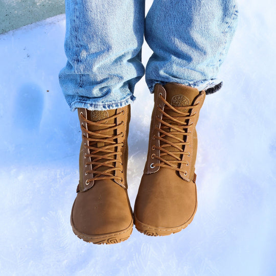 Vaistoa Hurmos 3 casual winter barefoot boots – lifestyle photo: pair from the front standing on snow with blue jeans, lacing visible