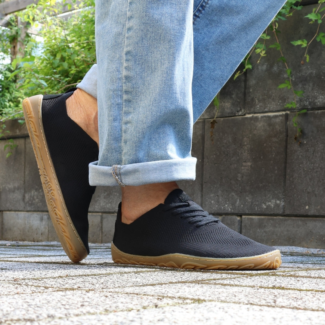 Vaistoa Iloa knitted barefoot sneakers – shoes worn on foot on a paved path beside a stone wall