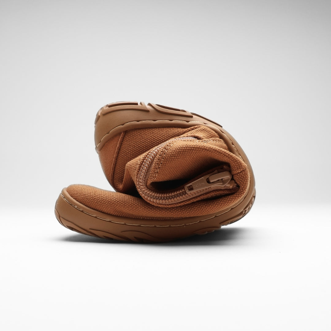 Vaistoa Kajo 2 barefoot chelsea boots – almond brown shoe folded in half with the side zipper visible, showing the thin flexible sole against a light background