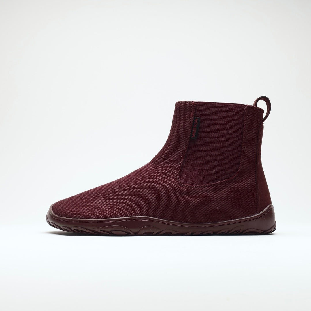 Vaistoa Kajo 2 barefoot chelsea boots – burgundy shoe shown from the side with the elastic panel visible, flat zero-drop sole against a light background
