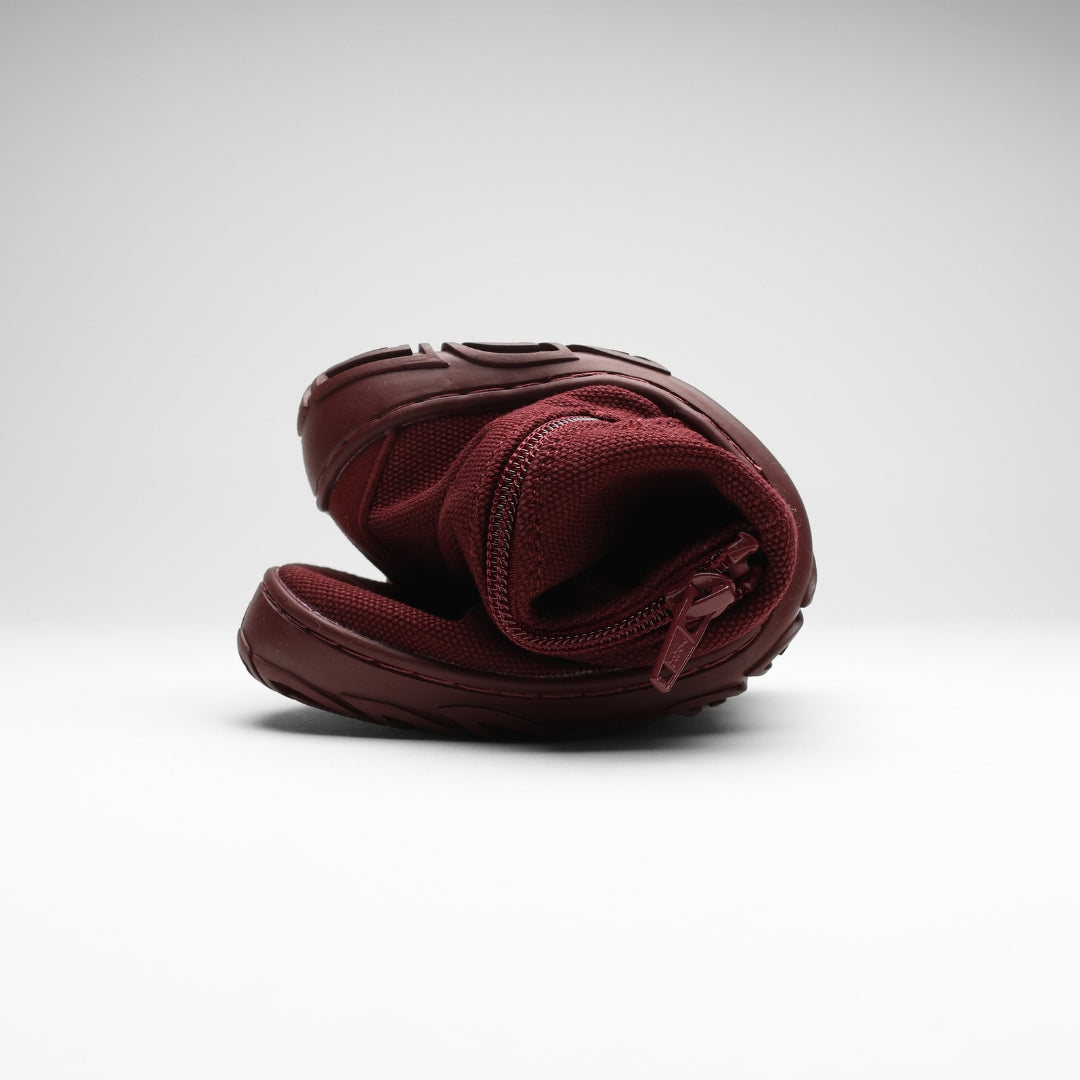 Vaistoa Kajo 2 barefoot chelsea boots – burgundy shoe folded in half with the side zipper visible, showing the thin flexible sole against a light background