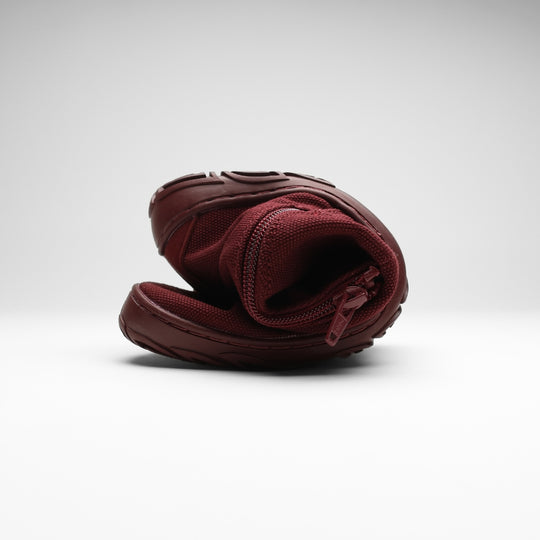 Vaistoa Kajo 2 barefoot chelsea boots – burgundy shoe folded in half with the side zipper visible, showing the thin flexible sole against a light background
