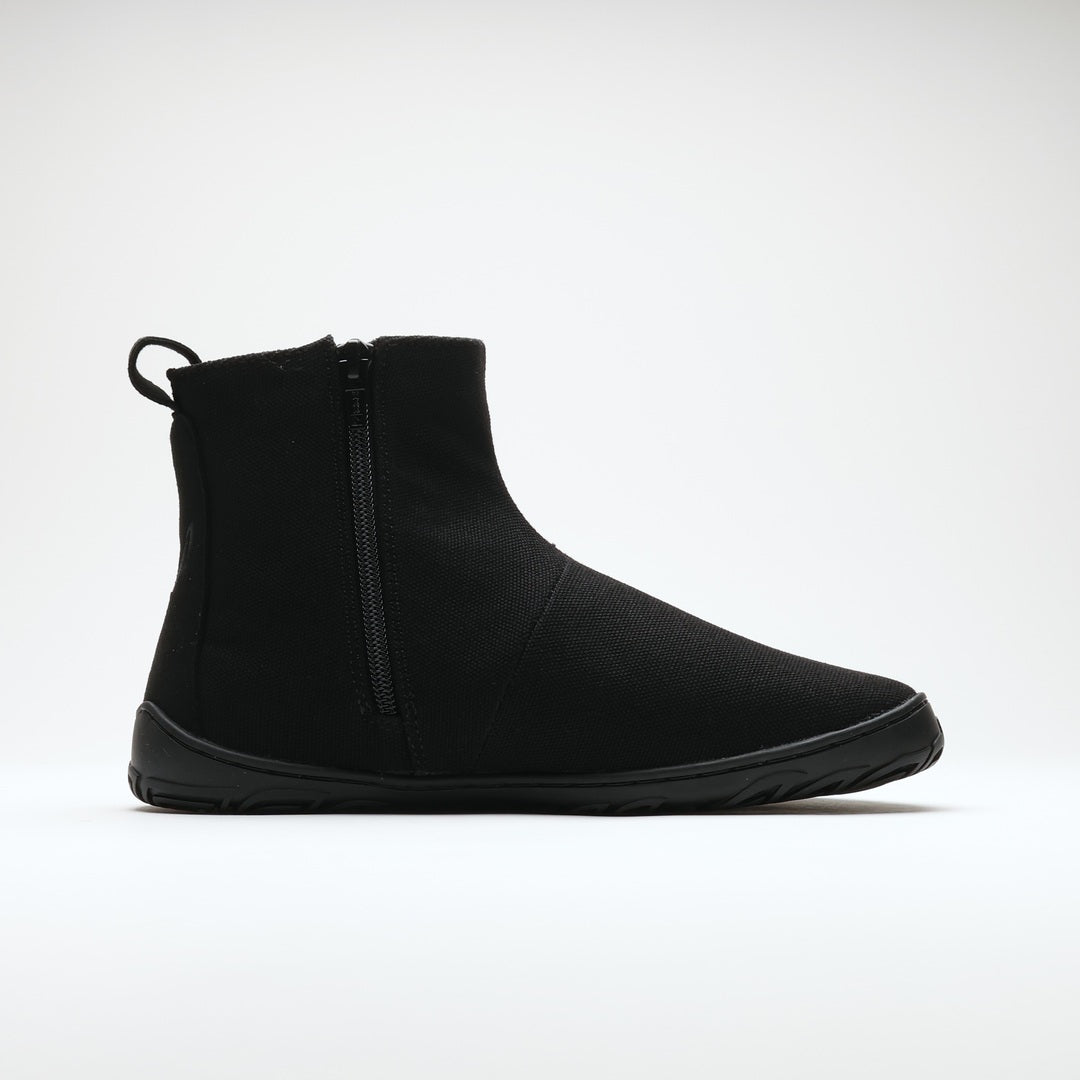 Vaistoa Kajo 2 barefoot chelsea boots – classic black shoe shown from the side with the side zipper visible, flat zero-drop sole against a light background