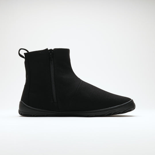 Vaistoa Kajo 2 barefoot chelsea boots – classic black shoe shown from the side with the side zipper visible, flat zero-drop sole against a light background