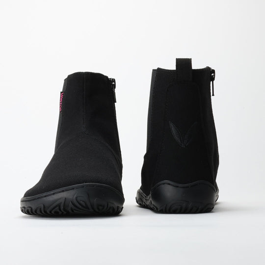 Vaistoa Kajo barefoot Chelsea boots – black, studio shot of the pair, one boot from the front and the other from behind, zipper and heel loop visible
