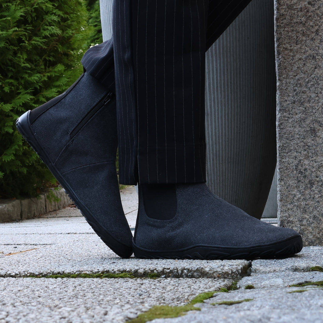 Vaistoa Kajo barefoot Chelsea boots – smoky stonewashed grey, boots worn with pinstripe suit trousers, standing on a paved street with conifers behind