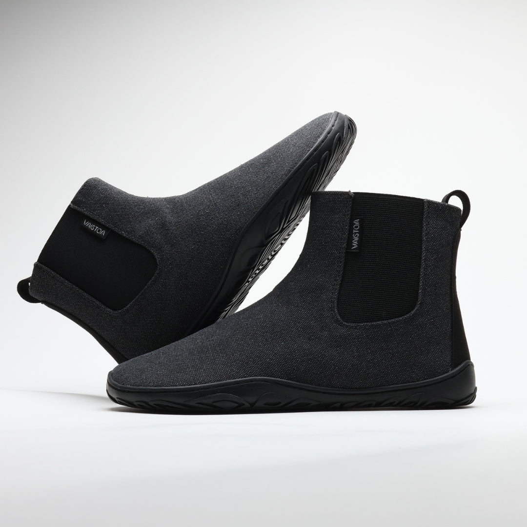Vaistoa Kajo barefoot Chelsea boots – smoky stonewashed grey, studio shot of the pair, the back boot tilted onto the front one, elastic side panel and the Vaistoa label visible