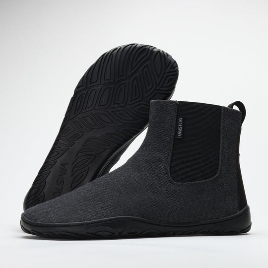 Vaistoa Kajo barefoot Chelsea boots – smoky stonewashed grey, studio shot of the pair, one boot tilted with the leaf-patterned outsole towards the camera and the other standing beside it