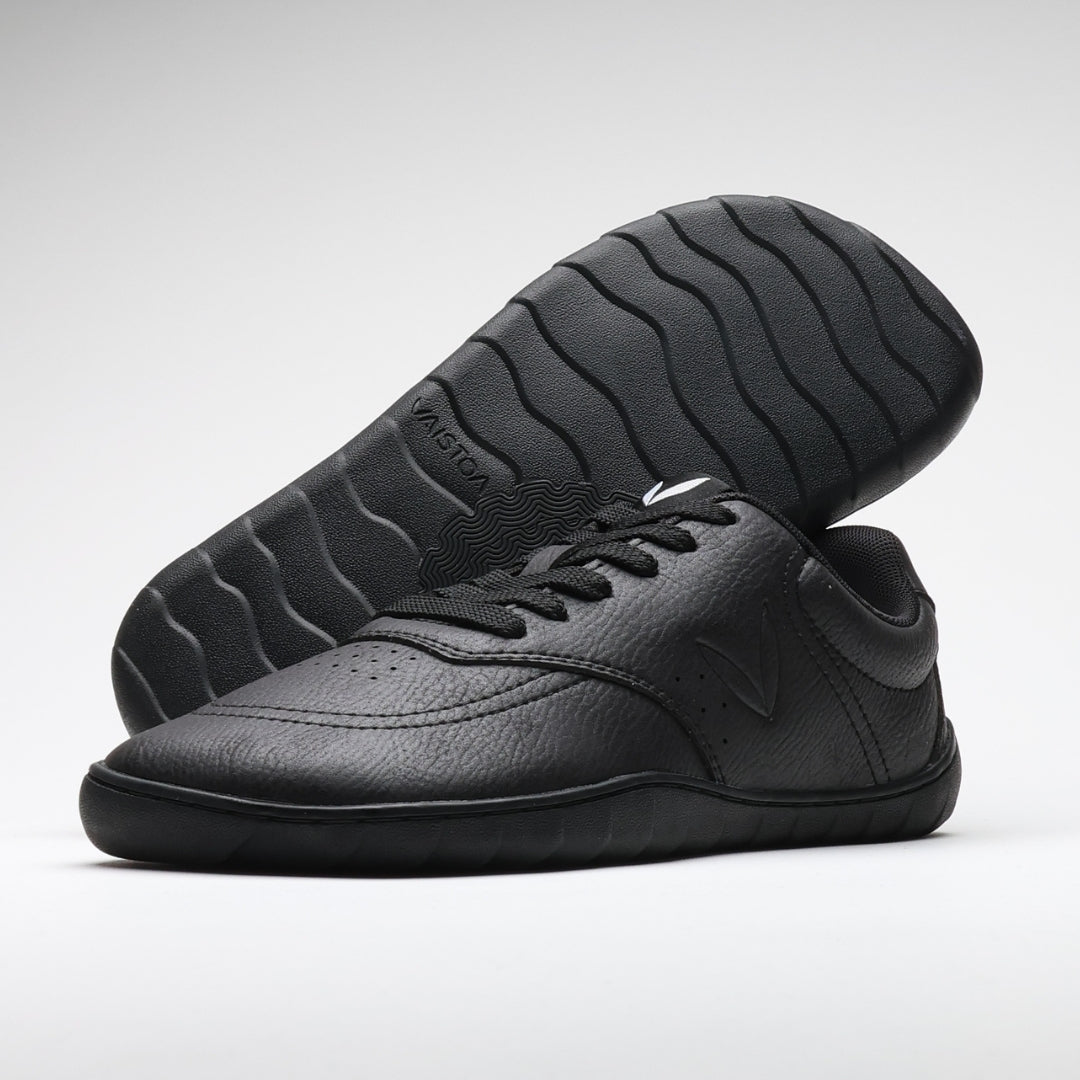 Vaistoa Katu 2 black barefoot sneakers – minimalist leather-like surface and flat, flexible sole. One shoe pictured with sole visible, featuring the Design from Finland mark.