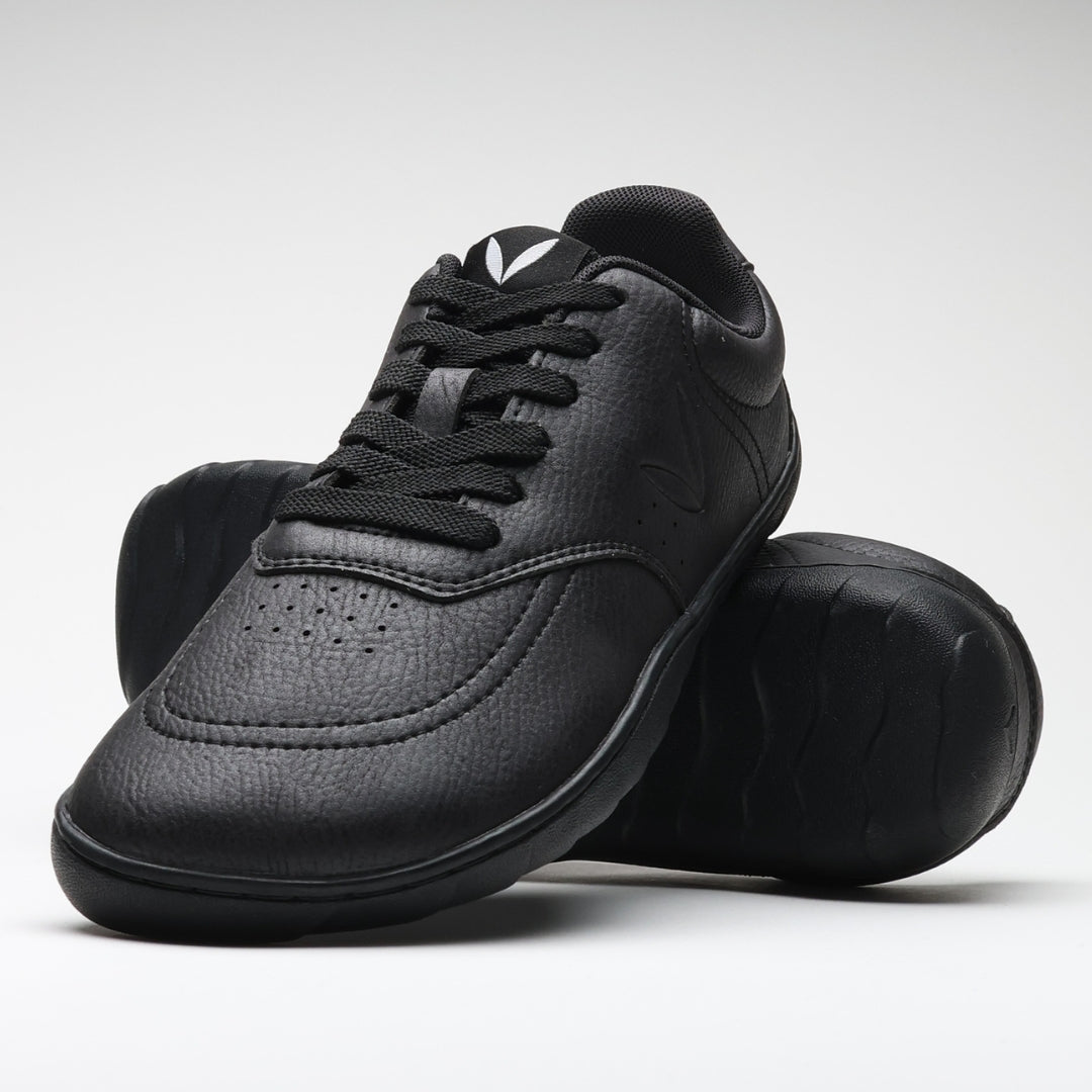 Vaistoa Katu 2 black barefoot sneakers – stylishly arranged so that one shoe leans against the sole of the other, highlighting the minimalist design and flexibility of the thin sole.