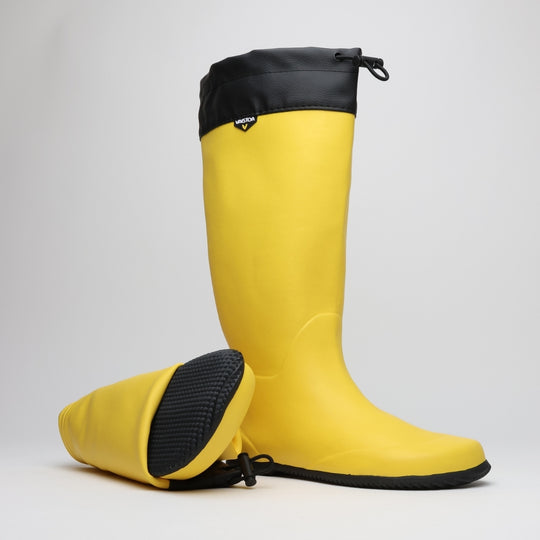 Vaistoa Katve 2 barefoot rubber boots yellow one boot standing upright and the other rolled up beside it against a studio background