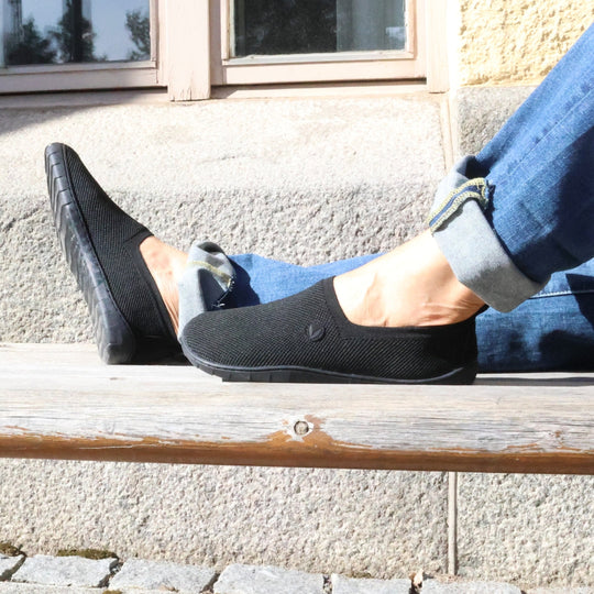 Vaistoa Lempeä 2 barefoot slip-on shoes black – lifestyle photo, spring outfit, blue jeans sitting on bench