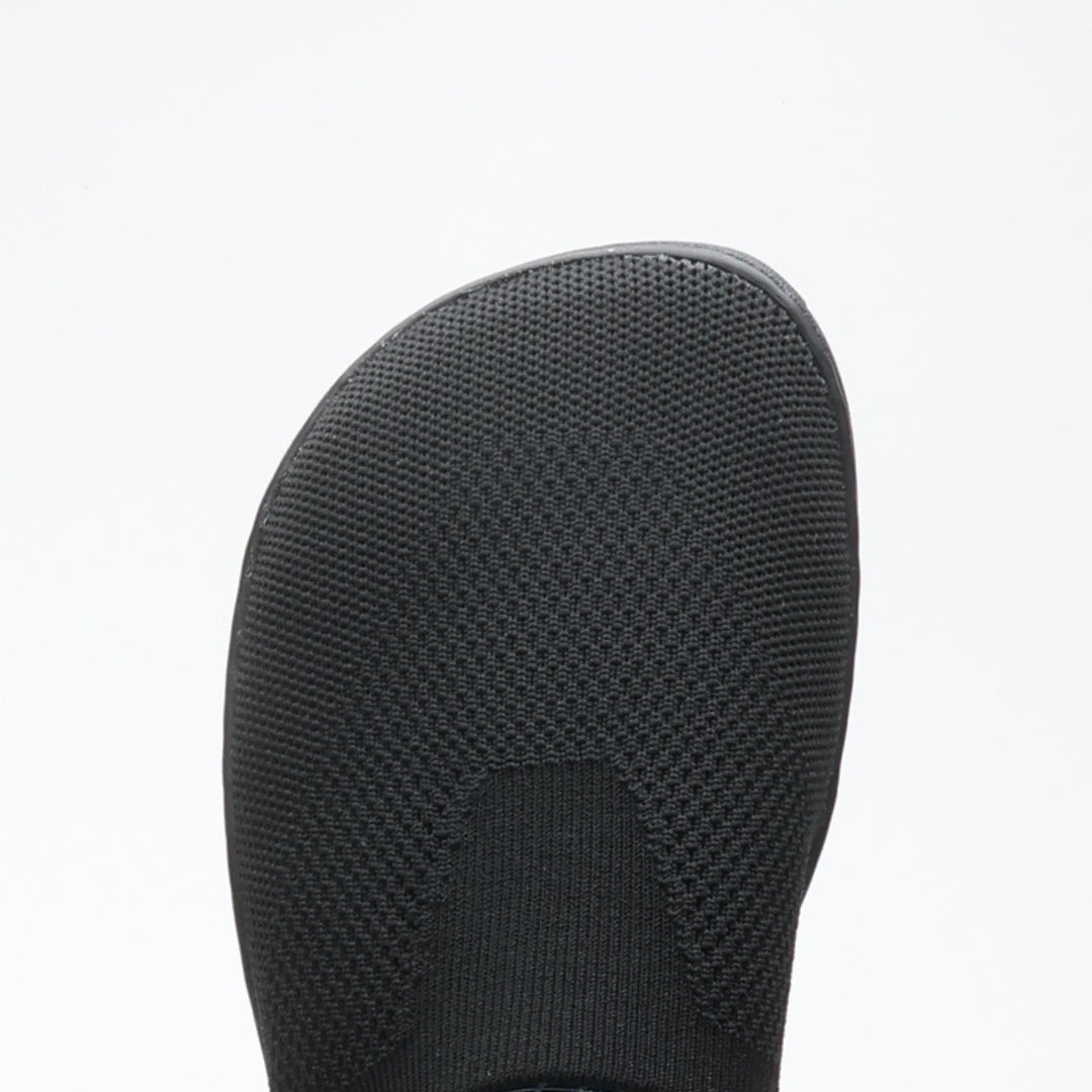 Close-up of black Vaistoa Lempeä 3 slip-on barefoot shoe upper showing knit texture and wide foot-shaped toe box