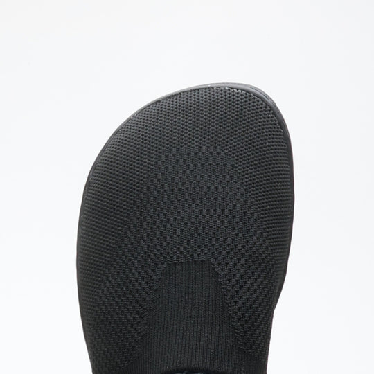 Close-up of black Vaistoa Lempeä 3 slip-on barefoot shoe upper showing knit texture and wide foot-shaped toe box