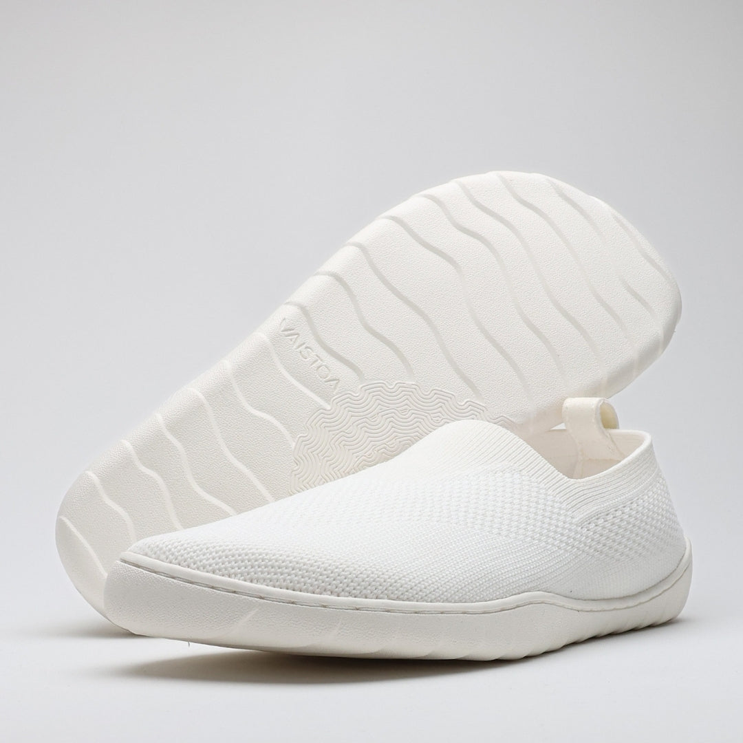 White Vaistoa Lempeä 3 slip-on barefoot shoes shown as a pair from an angled view with outsole visible