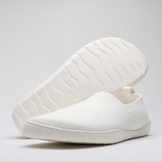White Vaistoa Lempeä 3 slip-on barefoot shoes shown as a pair from an angled view with outsole visible