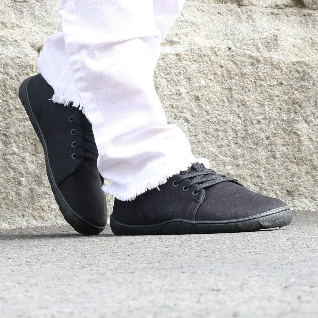 vaistoa rento 2 barefoot shoes low top canvas sneakers black lifestyle spring city white pants closeup