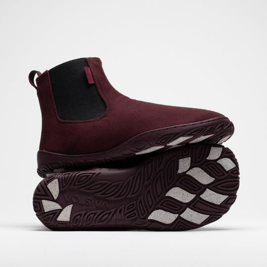 Vaistoa Sulo 2 winter barefoot chelsea boots – one shoe standing on top of the other shoe's outsole, showing the elastic panel of the upper shoe and the Vaistoa logo and grip pads on the outsole below