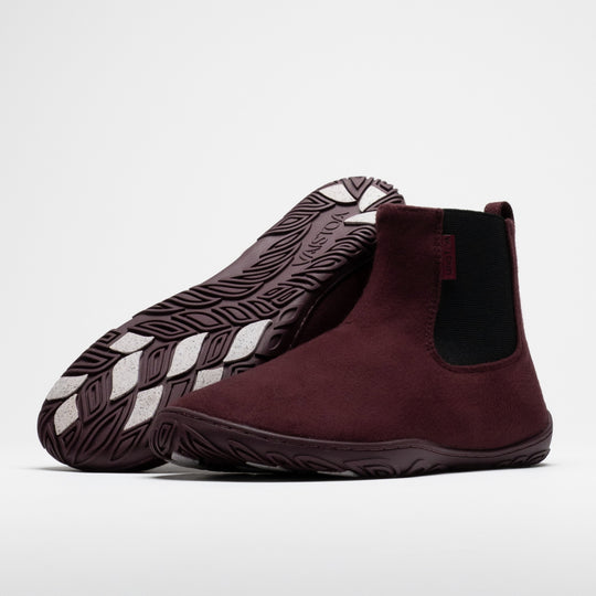 Vaistoa Sulo 2 winter barefoot chelsea boots – pair with the front shoe showing the elastic panel side and the second shoe leaning against its shaft with the outsole facing the camera, showing the tread pattern and grip pads
