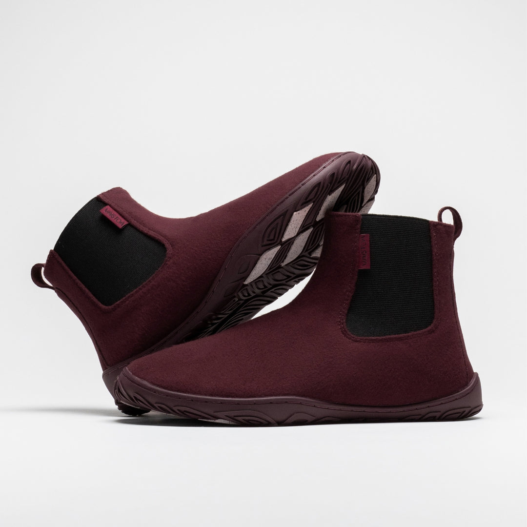 Vaistoa Sulo 2 winter barefoot chelsea boots – pair with one shoe lying on its side behind with the outsole angled upward and the other standing in front, the elastic panels of both visible