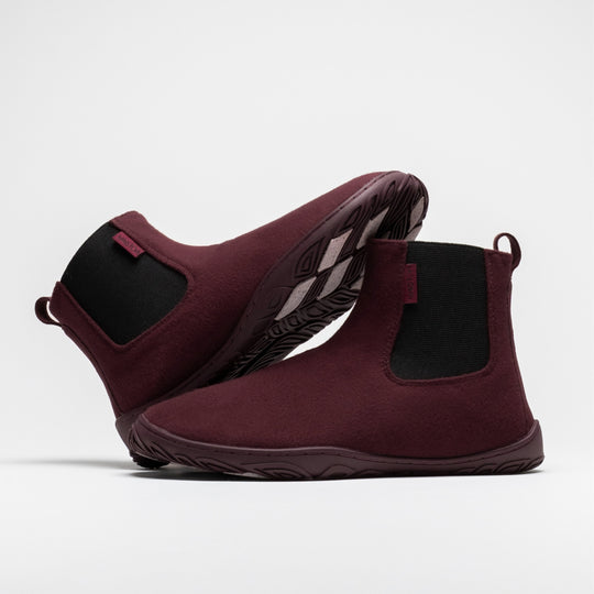 Vaistoa Sulo 2 winter barefoot chelsea boots – pair with one shoe lying on its side behind with the outsole angled upward and the other standing in front, the elastic panels of both visible