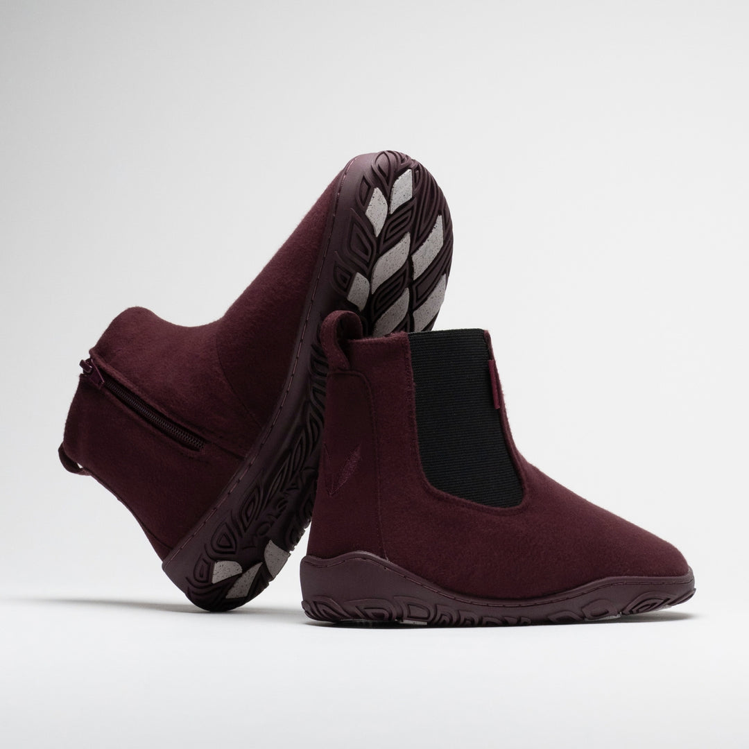 Vaistoa Sulo 2 winter barefoot chelsea boots – pair with one shoe tilted on its side showing the zipper and the grip pads on the outsole and the other standing next to it with the Vaistoa leaf symbol on the heel
