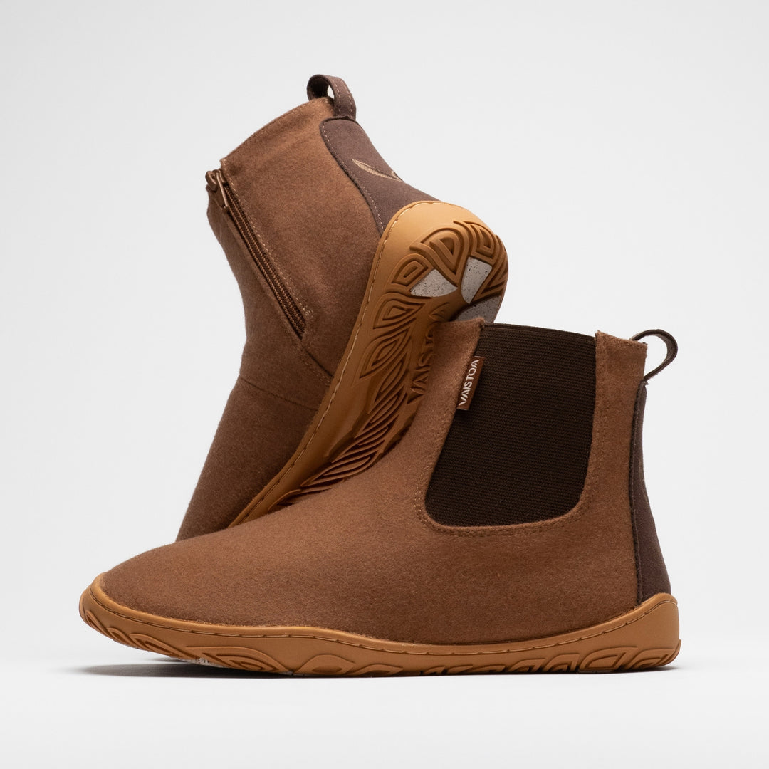 Vaistoa Sulo 2 winter barefoot chelsea boots – pair with the front shoe showing the elastic panel and the second shoe leaning against its shaft behind it, showing the zipper and the grip pads at the heel, against a light background