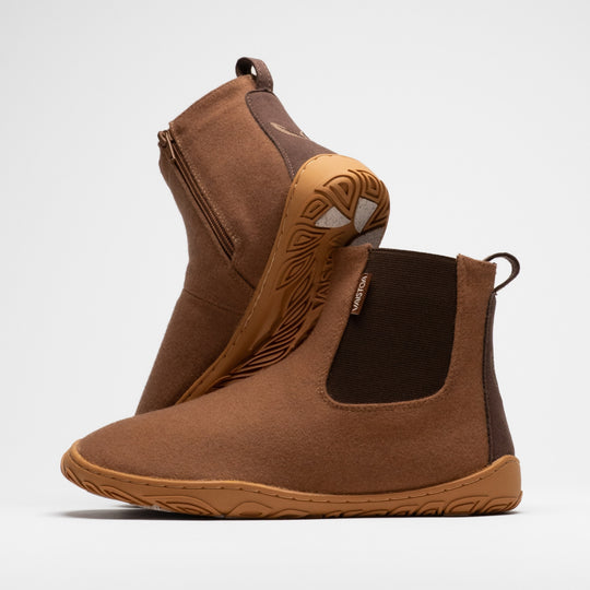 Vaistoa Sulo 2 winter barefoot chelsea boots – pair with the front shoe showing the elastic panel and the second shoe leaning against its shaft behind it, showing the zipper and the grip pads at the heel, against a light background
