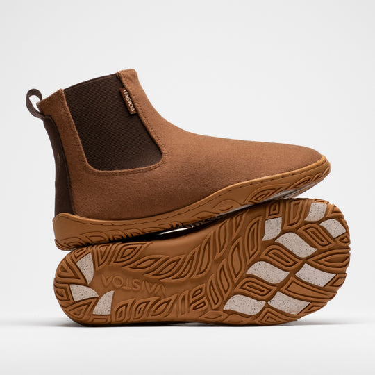Vaistoa Sulo 2 winter barefoot chelsea boots – one shoe standing on top of the other shoe's outsole, showing the elastic panel of the upper shoe and the Vaistoa logo and grip pads on the outsole below