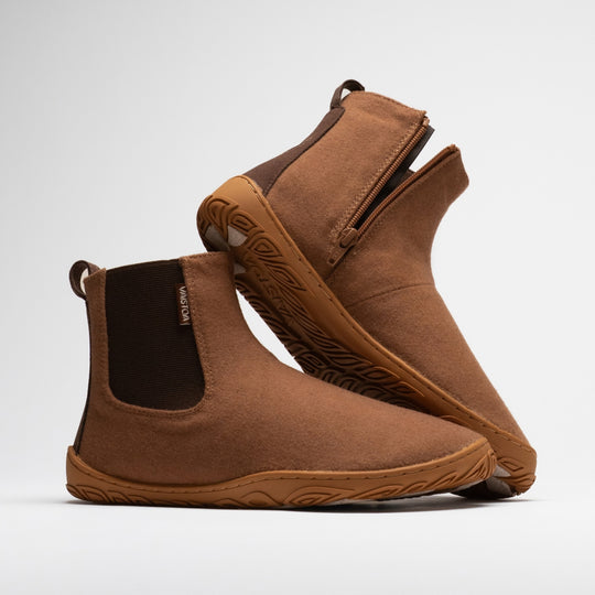 Vaistoa Sulo 2 winter barefoot chelsea boots – pair with the front shoe shown from the side with the elastic panel and the second shoe leaning against its shaft, showing the zipper and the edge of the outsole